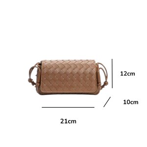 Puede incluir: Bolso bandolera marr&oacute;n tejido. El bolso rectangular mide 21 cm de largo, 12 cm de alto y 10 cm de ancho. Presenta un dise&ntilde;o trenzado y una correa para el hombro. El bolso es de color neutro, adecuado para varios conjuntos.