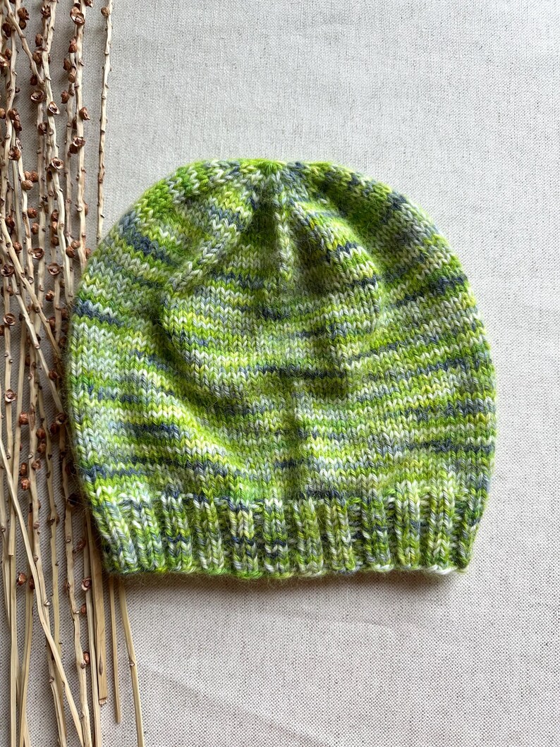 May include: A green, white and grey striped knitted beanie hat.