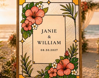 Puede incluir: Un letrero de boda rectangular en un marco dorado con un diseño estilo vitral, flores de hibisco rosas, hojas tropicales verdes y plumeria blanca. El texto central dice JANIE & WILLIAM y la fecha 08.30.2027 en fuente de color negro.