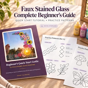 May include: A Faux Stained Glass Complete Beginner's Guide book with a purple cover, two sheets of practice patterns featuring floral, mushroom, and butterfly line art, four small bottles of colored paint, and a paintbrush on a wooden table.