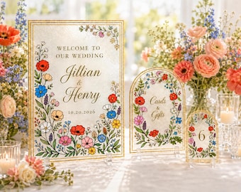 Puede incluir: Un letrero de bienvenida rectangular y dos letreros arqueados para tarjetas y regalos y el número de mesa seis, todos con bordes dorados e ilustraciones de flores silvestres coloridas con el texto Welcome to our wedding Jillian and Henry 10.20.2026.