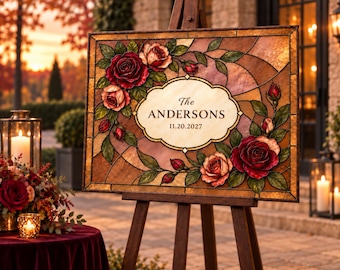 Puede incluir: Un letrero rectangular con un diseño de vidrieras con rosas rojas y rosas, hojas verdes y una placa central de color crema que muestra el texto The ANDERSONS 11.20.2027, todo montado sobre un caballete de madera.