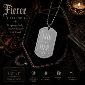 Puede incluir: Un colgante de placa de acero inoxidable plateado en una cadena de bolas. La placa presenta el texto grabado SHE HER, un símbolo de género femenino y estrellas. La placa mide 3,18 cm por 5,08 cm y tiene un acabado en color plata.
