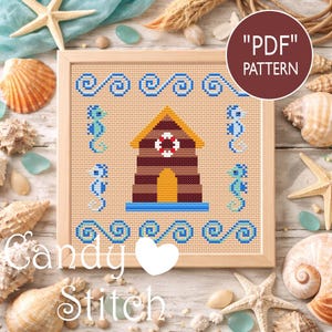 Puede incluir: Patrón de punto de cruz con una cabaña de playa con un salvavidas, caballitos de mar y patrones de olas en azul, marrón y amarillo. Los textos "Candy Stitch" y "PDF Pattern" son visibles. El diseño está enmarcado y rodeado de conchas marinas y estrellas de mar.