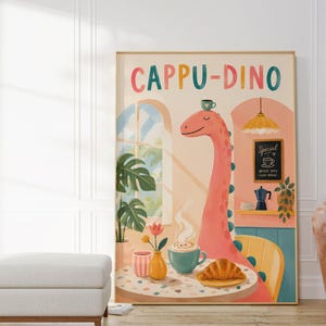 Könnte beinhalten: Ein vertikaler Wandkunstdruck mit dem Titel CAPPU-DINO, der einen rosa Dinosaurier mit langem Hals zeigt, der an einem Tisch mit einem Croissant, einer dampfenden Tasse Kaffee und einer Blumenvase sitzt. Der Hintergrund zeigt ein Café-Interieur.