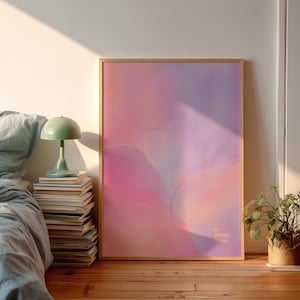 May include: A framed abstract art print with a soft color palette of pinks and purples. The artwork features a watercolor-like design with the text "my dreamy escape" in the lower right corner. The frame is a light wood color.