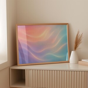 Könnte beinhalten: Ein rechteckiger gerahmter Druck mit einem abstrakten Farbverlauf in sanftem Orange, Pink, Violett und Türkis mit fließenden, wellenartigen Mustern. In der Mitte des Kunstwerks befindet sich ein kaum lesbarer weißer Text.