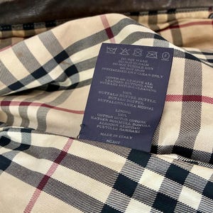 Etichetta con composizione e istruzioni di lavaggio. Fodera interna con motivo scozzese Burberry.