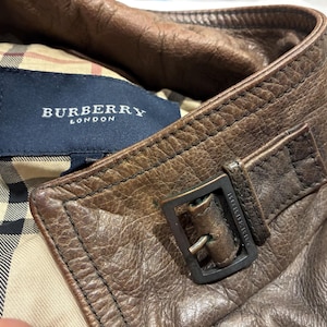 dettagli: colletto, fibbia di metallo con logo inciso, etichetta Burberry e fodera scozzese interna