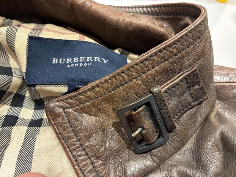 dettagli: colletto, fibbia di metallo con logo inciso, etichetta Burberry e fodera scozzese interna