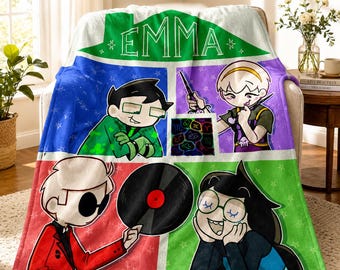 May include: A soft fleece throw blanket featuring a colorful grid design with the name EMMA printed at the top. The blanket displays four distinct cartoon character illustrations, including a vinyl record, a zodiac symbol grid, and stars.