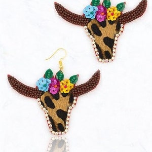 May include: A pair of brown beaded earrings with a floral design and a leopard print skull. The earrings are made with colorful beads and rhinestones.