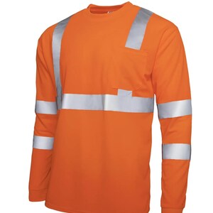 K&ouml;nnte beinhalten: Orangefarbenes Langarm-Arbeitshemd mit reflektierenden silbernen Streifen auf Schultern und &Auml;rmeln. Es hat eine Brusttasche und einen Rundhalsausschnitt. Das Hemd besteht aus strapazierf&auml;higem Material.