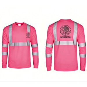K&ouml;nnte beinhalten: Lang&auml;rmeliges, pinkfarbenes Arbeits-T-Shirt mit silbernen Reflexstreifen an &Auml;rmeln und Brust. Das Shirt hat einen Rundhalsausschnitt und ein Logo mit Telefonnummer auf der Vorder- und R&uuml;ckseite.
