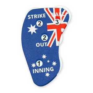 May include: A blue baseball umpire indicator featuring the Australian flag design with white stars and a red, white, and blue Union Jack. The device displays the text STRIKE, BALL, OUT, and INNING with white circular dials showing the numbers 1, 2, and 3.