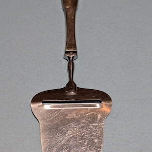 Può includere: Una tazza di ceramica bianca con un manico nero e la scritta "But First, Coffee" in stile scritto a mano. La tazza è su una superficie bianca. La tazza è alta circa 10 cm.