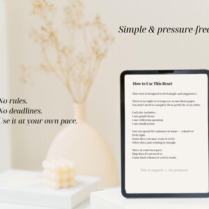 Puede incluir: Una tableta digital muestra el texto: "C&oacute;mo usar este reinicio". La imagen incluye texto: "Simple y sin presi&oacute;n", "Sin reglas. Sin plazos. &Uacute;selo a su propio ritmo". Tambi&eacute;n se ven un jarr&oacute;n blanco y una pila de libros.