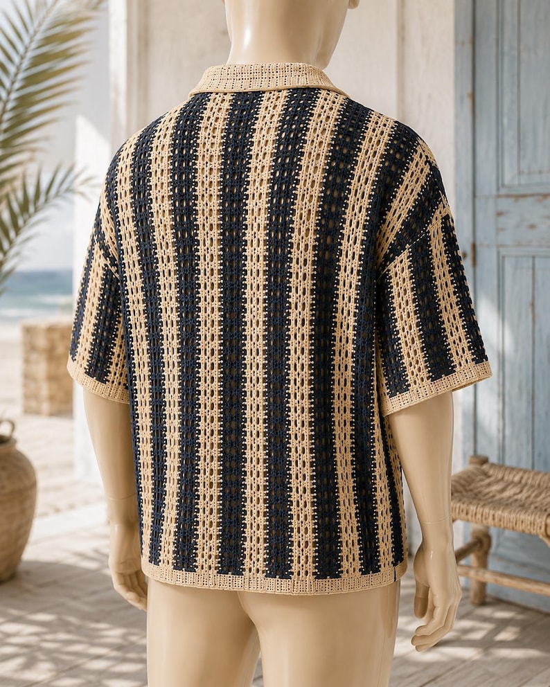 May include: A short-sleeved shirt featuring a vertical striped pattern in alternating dark navy blue and beige colors. The garment is constructed with an open-knit crochet texture, a standard collar, and a straight hemline, displayed on a mannequin.