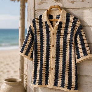May include: A short-sleeved button-down shirt featuring a vertical striped pattern in cream and navy blue. The garment is crafted from a crochet knit fabric with an open-work texture, a classic collar, and four brown buttons down the front center.