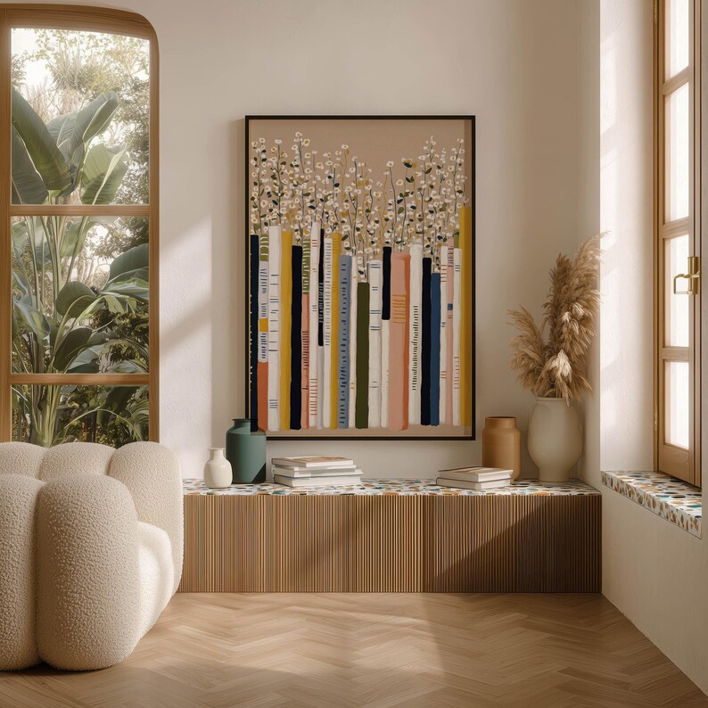 Stylish art print of a whimsical bookshelf and daisy garden in soft neutrals, hanging above a ribbed bench with books and vases by arched windows.