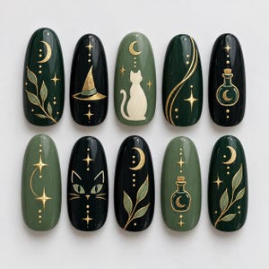 May include: A set of ten oval-shaped press-on nails in dark green and black, featuring gold-painted celestial motifs including crescent moons, stars, a cat silhouette, a witch hat, potion bottles, and botanical leaf designs on each individual nail.