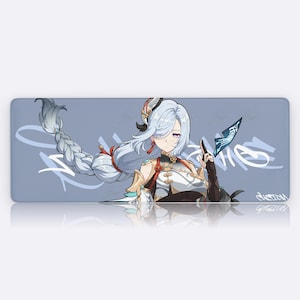 May include: A rectangular mouse mat featuring an anime-style illustration of a character with long, braided white hair and a detailed outfit. The background is a light blue with white graffiti-style text and a reflection.