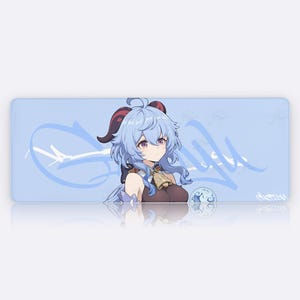 Puede incluir: Alfombrilla de escritorio rectangular azul claro con una ilustración de dibujos animados de un personaje con cabello y cuernos azules. El personaje se encuentra sobre un fondo azul claro con texto y elementos de diseño blancos estilizados. También hay un pequeño orbe azul.