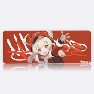 Puede incluir: Una alfombrilla de ratón rectangular roja con un personaje de dibujos animados con pelo rubio y un atuendo rojo. La alfombrilla tiene texto blanco estilizado y el personaje está saludando. La alfombrilla tiene una superficie reflectante.