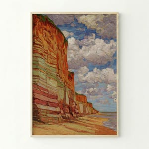 May include: Oil painting depicting a coastal scene with layered cliffs in shades of red, orange, and green. A sandy beach and the sea are visible beneath a cloudy blue sky. The artwork is framed.