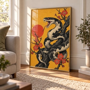 Può includere: Una stampa artistica da parete incorniciata raffigurante un serpente bianco e nero con la bocca aperta e le zanne visibili, avvolto attorno a un ramo d'albero scuro. Lo sfondo è giallo vibrante con un grande cerchio rosso e fiori rossi.