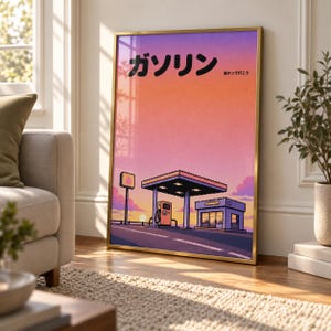 May include: A framed vertical wall art print featuring a pixel art illustration of a petrol station at sunset. The sky transitions from purple to orange. The Japanese text reads "Gasorin" and "Mantande ikou". The frame is a thin metallic gold colour.