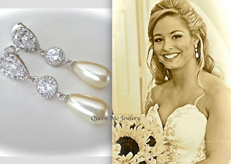 May include: Elegant silver-toned drop earrings with clear, sparkling crystals and pear-shaped faux pearls. The earrings are displayed next to a smiling woman in a wedding dress. The text "Queen Me Jewlery" is visible.