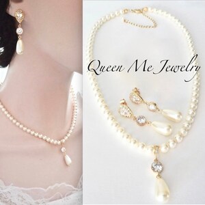 May include: A pearl necklace and matching earrings set. The necklace and earrings feature small, round pearls with a gold-colored pendant and earring accents. The earrings have a teardrop-shaped pearl drop.