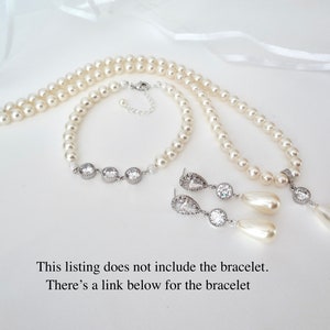 May include: A pearl necklace, bracelet, and earrings set. The necklace and bracelet are made of round pearls. The earrings have a teardrop pearl and a round, clear stone. The text on the image says, "This listing does not include the bracelet."