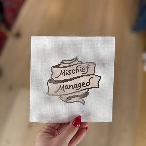 May include: A white ceramic mug with a black handle and the text "But First, Coffee" in a black, handwritten-style font. The mug is on a white surface.