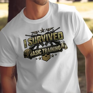 Może przedstawiać: Biała koszulka z grafiką o tematyce wojskowej. Projekt zawiera napis "I Survived Basic Training" w czcionce moro, a także obrazy karabinów, hełmu, nieśmiertelników i gwiazd. Koszulka ma okrągły dekolt.