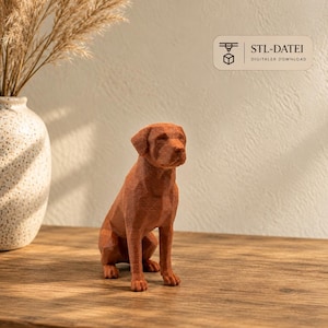 May include: A brown, low-poly geometric dog figurine in a sitting position. The surface features a faceted texture. A rectangular label in the upper right corner displays a 3D printer icon and the text STL-DATEI DIGITALER DOWNLOAD.