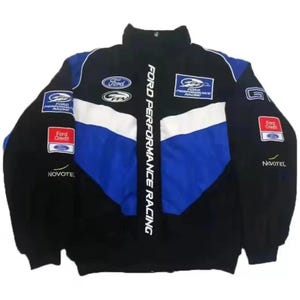 May include: Black racing jacket with blue and white panels. It displays the Ford logo, Ford Performance Racing text, and Ford Credit logos. The jacket has a high collar and various patches.