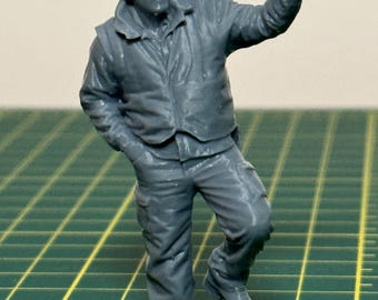 Unpainted G Scale figurine train crew member standing on a step holding onto a railing