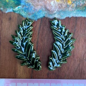 Paquete de baldosas cerámicas con diseño de hojas variadas, en color verde transparente.