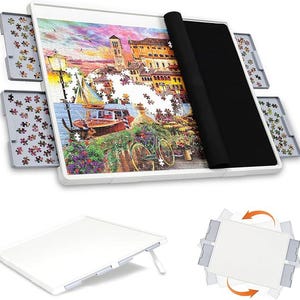 May include: A white puzzle board with a partially completed jigsaw puzzle depicting a colorful cityscape with a boat and flowers. The board includes gray sorting trays and a black felt mat for storage. The board is shown in multiple positions.
