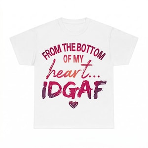 May include: A white short-sleeved t-shirt featuring a graphic print with the text "FROM THE BOTTOM OF MY heart... IDGAF" in a gradient of red, pink, and purple colors, accompanied by a small heart icon centered below the text.