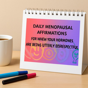Könnte beinhalten: Ein weißer Schreibtischkalender mit dem Text "Daily Menopausal Affirmations for When Your Hormones Are Being Utterly Disrespectful." Eine weiße Tasse mit Kaffee und zwei Stifte befinden sich ebenfalls auf dem Schreibtisch.