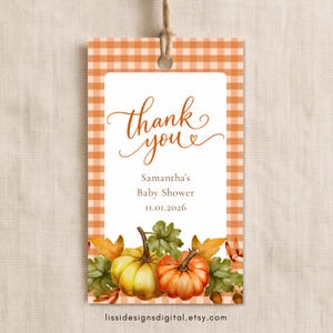 Puede incluir: Una etiqueta de regalo rectangular con un borde de cuadros vichy naranja y blanco. El centro presenta el texto "thank you", "Samantha's Baby Shower" y "11.01.2026" sobre una ilustración en acuarela de dos calabazas y hojas.