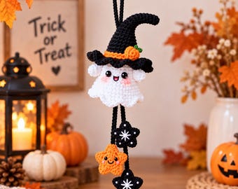 May include: A crocheted ghost ornament wearing a black witch hat with a small orange pumpkin accent. The ghost has a white body, pink cheeks, and black eyes. Below the ghost hang three crocheted stars, two black with white star details and one orange.