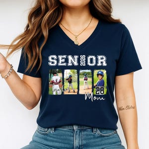 May include: Navy blue v-neck t-shirt with the text "SENIOR 2026" in white block letters. Below the text are four rectangular images of a baseball player. The word "Taylor" and the number "28 Mom" are written in script below the images.