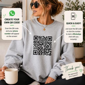May include: A light gray crewneck sweatshirt featuring a large black QR code printed on the center chest. The garment is shown with two informational text boxes explaining how to scan the code for WhatsApp and a thank you note at the bottom.