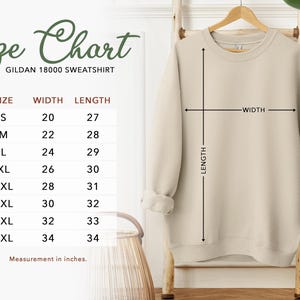 a size chart for a GILLET 1800 sweatshirt, with measurements for different sizes ranging from S to M. The chart also includes a picture of a sweatshirt hanging on a hanger, and there is a plant in the background.