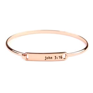 May include: Rose gold-colored bangle bracelet. The bracelet features a rectangular plate with the inscription "john 3:16". The bracelet is a simple, elegant design, suitable for everyday wear. The metal has a shiny finish.