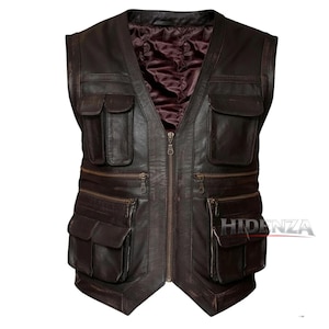 Può includere: Un gilet in pelle marrone scuro con tasche multiple e chiusura frontale con zip. Il gilet ha una fodera bordeaux trapuntata e una finitura invecchiata. Ha quattro tasche quadrate e due tasche con cerniera.